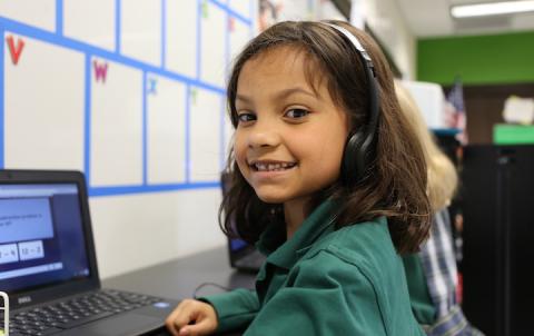 Student smiling at desk