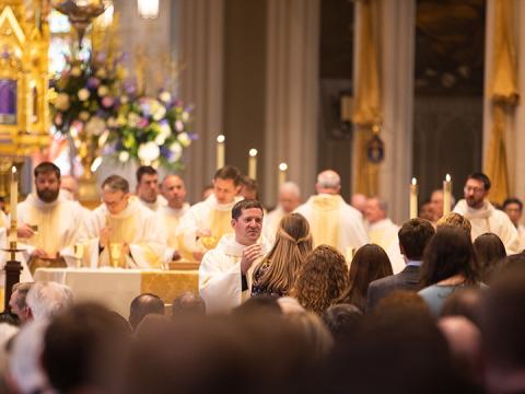 Fr. Drew Clary distributes communion for the first time as a priest