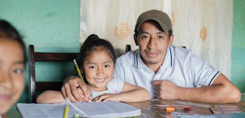 father and daughter doing school work at home