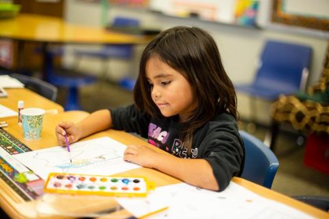 Student coloring at desk