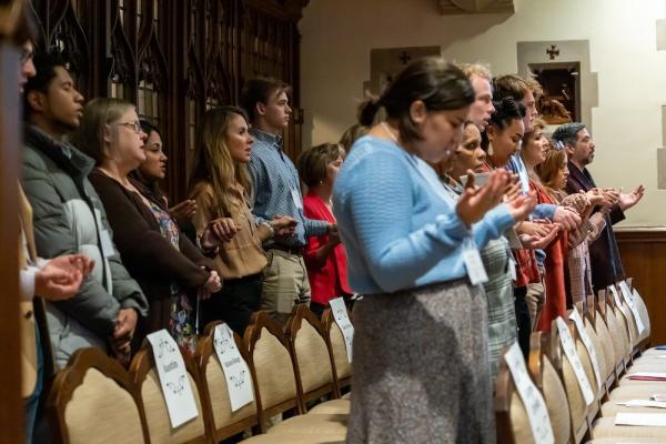 ACE teachers and principals holding hands during the Our Father in Mass