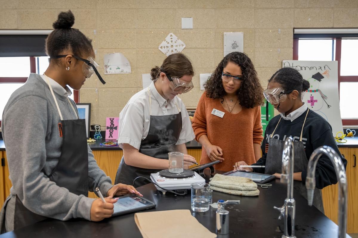 ACE teacher Jehdah Burton helping with a science experiment with her students