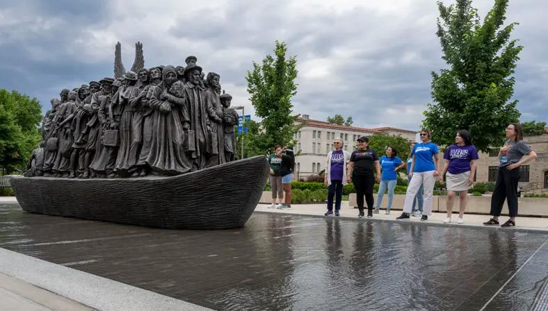 Dual language teachers stand at the monument