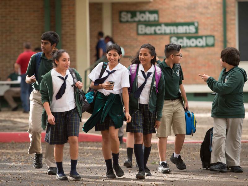 Students in uniform smiling and walking