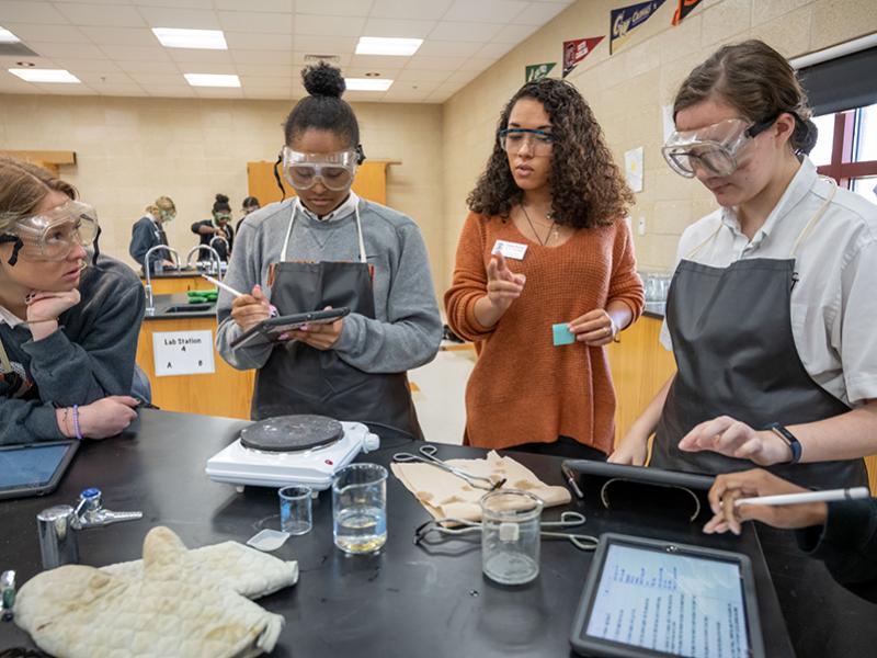 ACE Teacher with three students in a labratory.